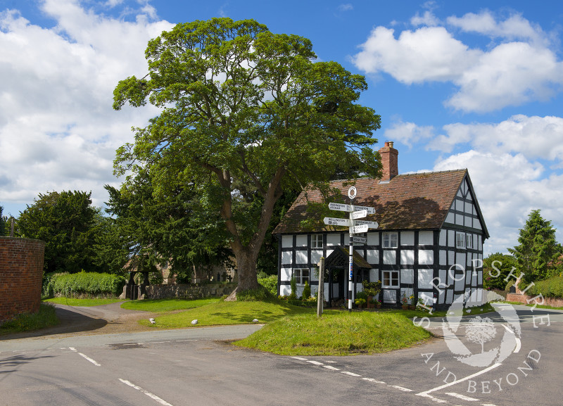 A black and white house and village signpost in Upton Magna, near Shrewsbury, Shropshire, England.