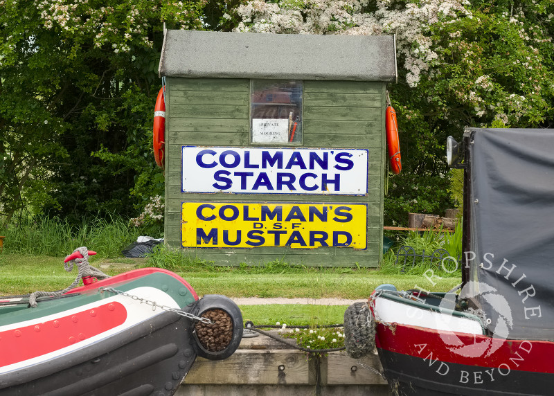 Vintage advertising signs on a hut alongside the Shropshire Union Canal at Norbury Junction,  Staffordshire.