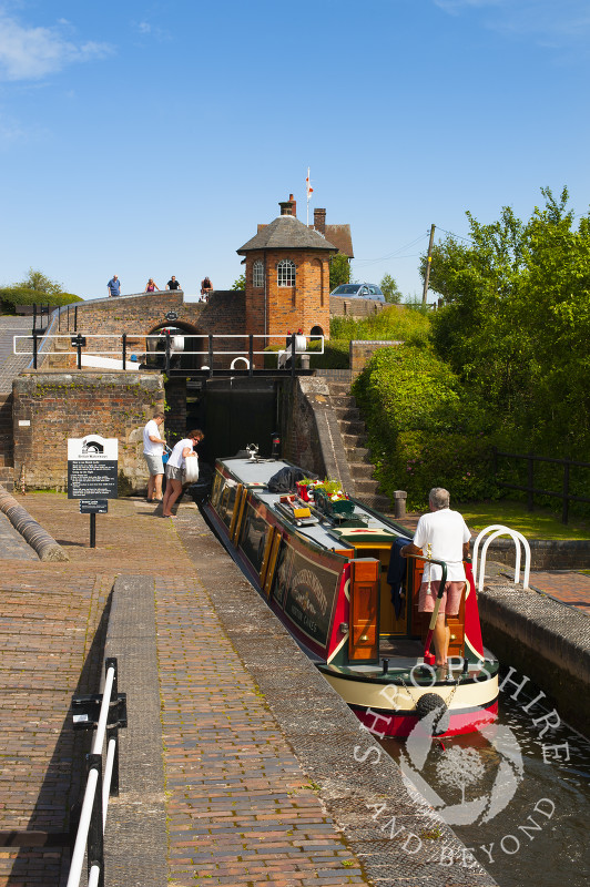 A canal boat passing through Bratch Locks at Wombourne, Staffordshire, England.